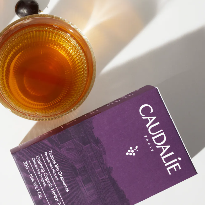 CAUDALIE Tisanas Bio Drenantes Vinosculpt  Tipo de piel : Cuerpo Necesita : Drenante Ingredientes clave : Mezcla de 5 plantas bio Textura : Tisana Use : Día y noche ¿Qué es? Las Tisanas Drenantes Biológicas son una exquisita mezcla drenante y relajante de cinco plantas biológicas: vid roja, corteza de naranja, arándano, grosella negra y canela. Creadas en exclusiva para la sala de té del Spa Vinothérapie™, ayudan a drenar las toxinas y a combatir la retención de agua para afinar la silueta.