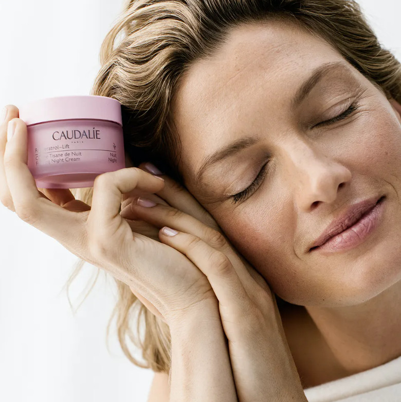 CAULADIE Crema Tisana de Noche Resveratrol-lift  Tipo de piel : Todo tipo de pieles Necesita : Firmeza Ingredientes clave : Aceite de pepitas de uva, Escualeno de oliva, Péptidos, Resveratrol, Booster de Colágeno Vegano, Ácido hialurónico Textura : Crema Use : Por la noche, después del suero ¿Qué es?  Una nueva patente presentada con booster de colágeno vegano aún más eficaz.  Gracias a su asociación patentada de Resveratrol, ácido hialurónico y booster de colágeno vegano, la Crema Tisana de Noche antiarrugas reconfortante regenera la piel para estar bella al despertar: los rasgos están descansados y alisados, la piel está firme, el cutis está radiante.  Compuesta en más de un 98% por ingredientes de origen natural y enriquecida con escualano de oliva, su textura de crema suave y untuosa nutre la piel y le proporciona una sensación de calma.  Su complejo fitoaromático deja la piel delicadamente perfumada con notas de flores de manzanilla, agua de lavanda, hojas de naranja, tomillo rojo, salvia y menta fresca.  El compromiso de Caudalie: Envases 100% reciclables para cumplir el objetivo de "cero residuos"* Cajas fabricadas con menos papel y sin revestimiento de plástico, es decir, un 40% menos de emisión de huella carbono.**